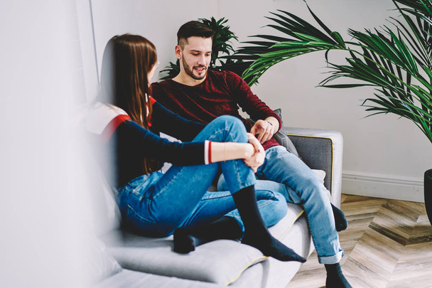 Couple in love communicating about relationship while spending leisure time together at cozy home interior, young marriage having conversation in modern apartment relaxing on comfortable sofa - Foto, afbeelding