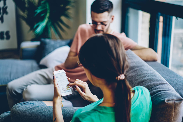 Addicted boyfriend and girlfriend ignoring live communication while chatting in social networks via modern smartphone gadgets using 4g wireless connection during leisure time in home interior - Valokuva, kuva