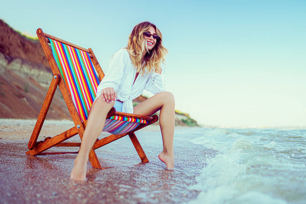 Pretty woman relaxing on a lounger beach. summer vacation concept - Фото, изображение
