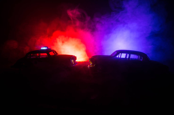 Coche de policía persiguiendo un coche por la noche con niebla de fondo. 911 Emergencia respuesta coche de policía exceso de velocidad a la escena del crimen. Enfoque selectivo - Foto, Imagen