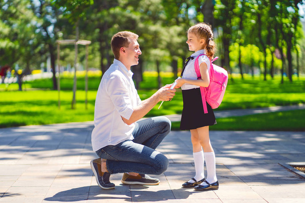 father leads daughter to school in first grade. first day at school. back to school - Фото, изображение