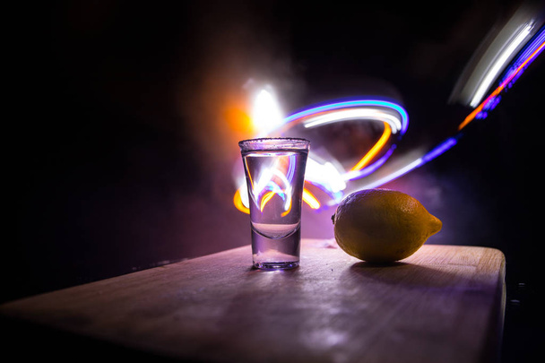 Концепция напитков. Вкусный алкоголь коктейль текила с лаймом и солью на ярком темном фоне или очки с текилой в баре
 - Фото, изображение