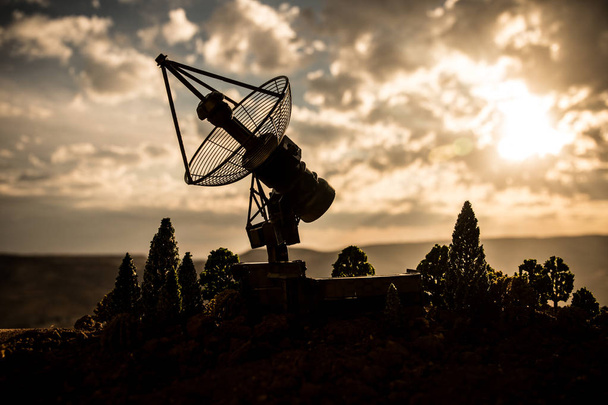 Silhouetten van satelliet gerechten of radioantennes tegen zonsondergang hemel. Ruimte observatorium. - Foto, afbeelding