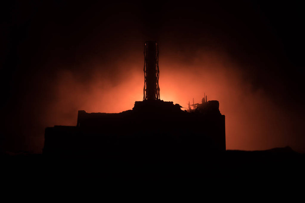 Δημιουργική διακόσμηση τέχνης. Το εργοστάσιο πυρηνικής ενέργειας του Τσερνομπίλ τη νύχτα. Διάταξη εγκαταλελειμμένου σταθμού του Τσερνομπίλ μετά από έκρηξη πυρηνικού αντιδραστήρα. - Φωτογραφία, εικόνα