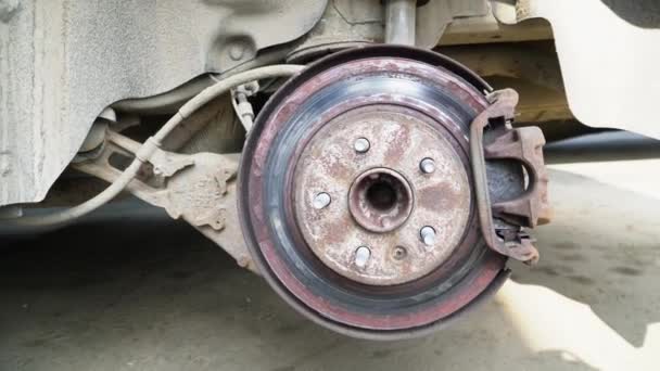 Disparo panorámico de un disco de freno oxidado en la pinza del coche
 - Metraje, vídeo