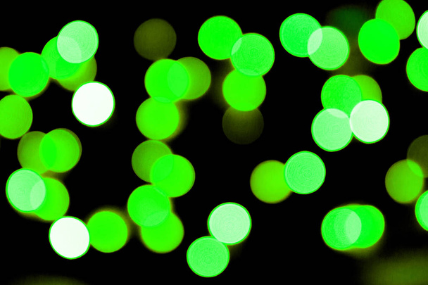 Несфокусированный черный фон. размыты и размыты многие круглые зеленый свет
 - Фото, изображение
