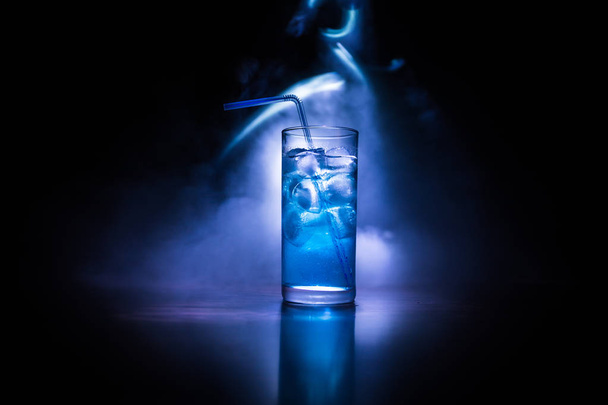Cocktailglas auf dunkel getöntem, rauchigen Hintergrund oder farbenfroher Cocktail im Glas. Party Club Unterhaltung. gemischtes Licht. - Foto, Bild