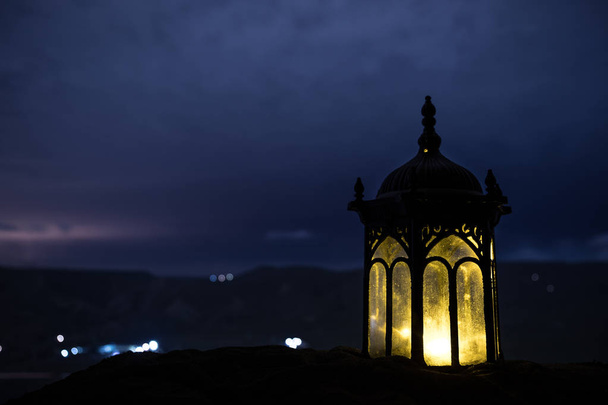 linterna árabe ornamental con vela encendida que brilla por la noche. Tarjeta de felicitación festiva, invitación para el mes sagrado musulmán Ramadán Kareem. - Foto, imagen