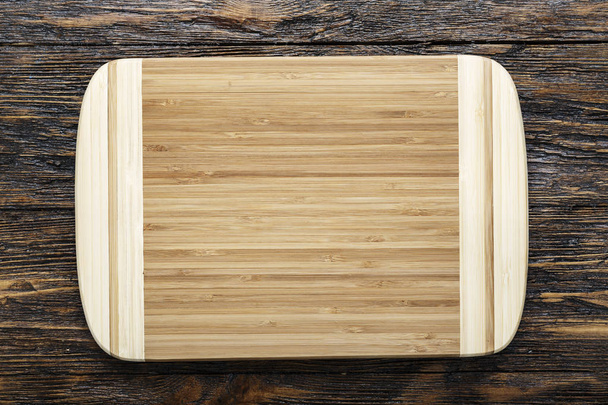Rectangular wooden cutting board made of light wood as a background - space for text. on brown wooden backgroun - Foto, Imagem