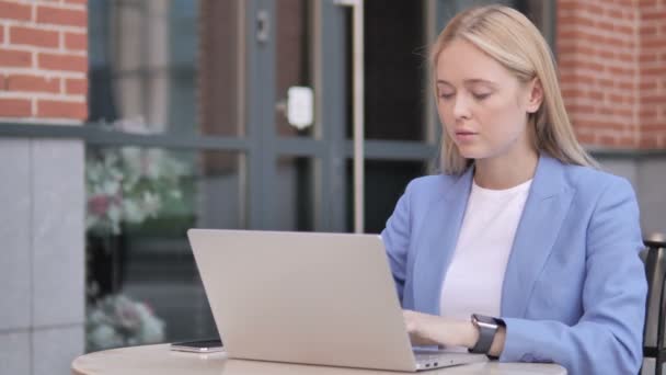 Jonge zakenvrouw hoesten tijdens het werken op een laptop buiten - Video