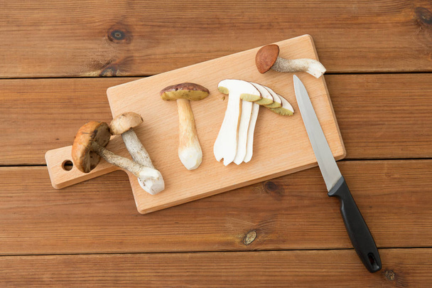 edible mushrooms, kitchen knife and cutting board - Foto, afbeelding