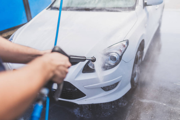 Close up of man hand washing car with pressure washer outdoors. - Fotografie, Obrázek
