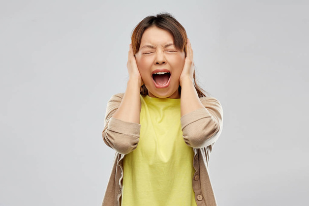 stressed asian woman closing ears and screaming - Fotografie, Obrázek