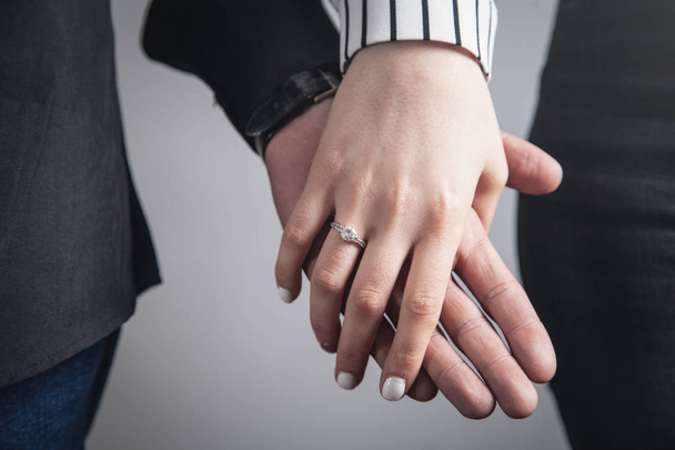 Hands of a guy and a girl with wedding ring. - Фото, изображение