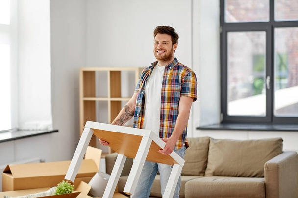 happy man with table moving to new home - Photo, Image