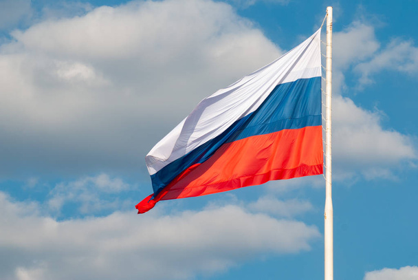 Russian flag waving in the wind against the blue sky, - Photo, Image