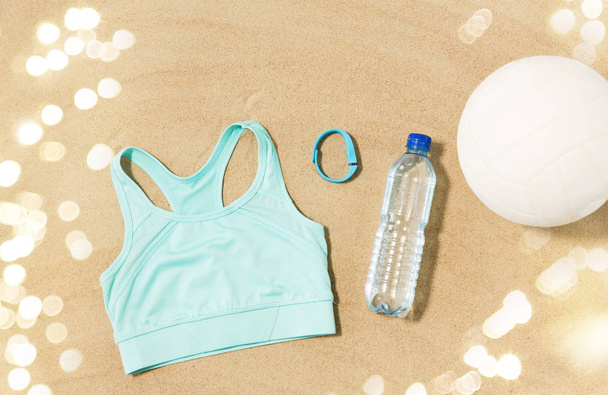 sports top, ball, fitness tracker and water bottle - Foto, imagen