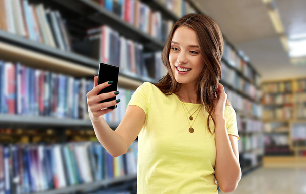 smiling teenage girl taking selfie by smartphone - Fotografie, Obrázek