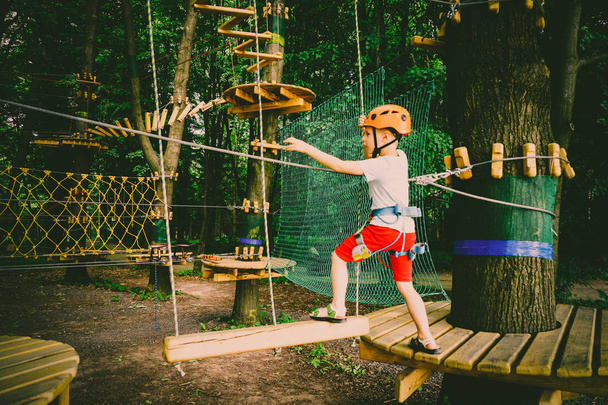 Der Junge klettert auf einen Pendelpark - Foto, Bild