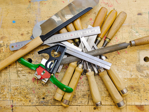 Различные инструменты для обработки древесины на старой поверхности деревянной скамейки
. - Фото, изображение