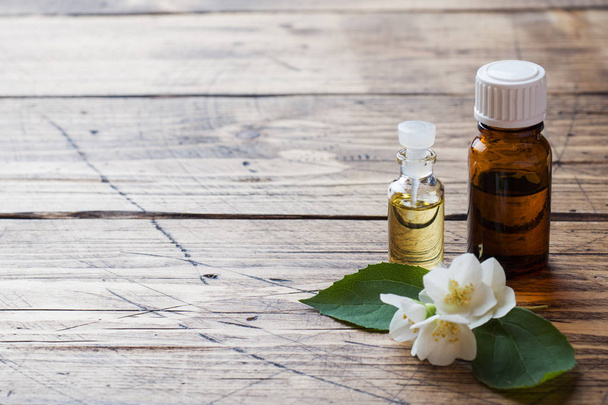 Oil of jasmine. Aromatherapy with jasmine oil. Jasmine flowers. Wooden background with copy space. - Фото, зображення