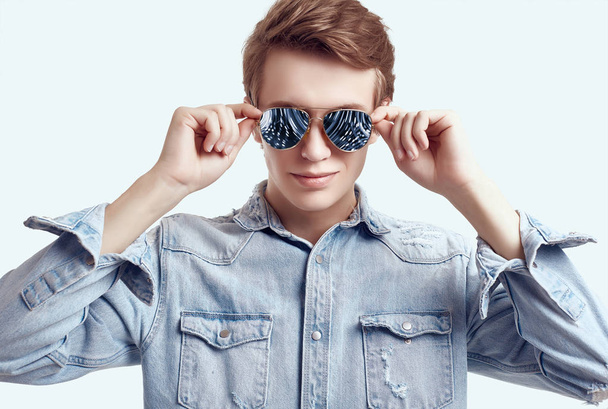 Pohledný hipíček v módních brýlích s džínsy - Fotografie, Obrázek