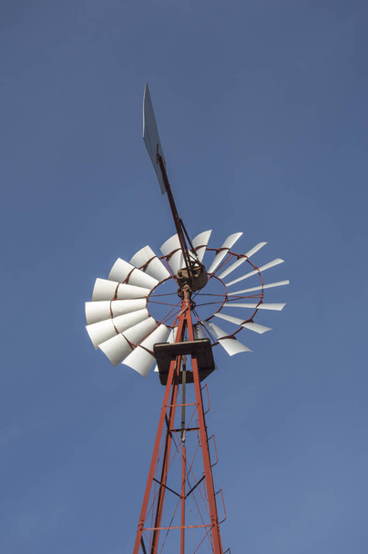 Starý americký mlýn byl izolován a oříznut přes modrou oblohu s mraky v parku Quinta De Los Molinos v Madridu. Španělsko. - Fotografie, Obrázek