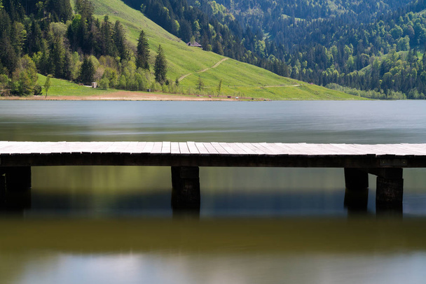 longue promenade en bois sur un lac de montagne calme et paisible avec un
  - Photo, image