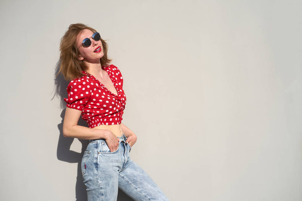 Pelirroja chica caucásica en rojo de lunares patrón blusa y jean
 - Foto, Imagen