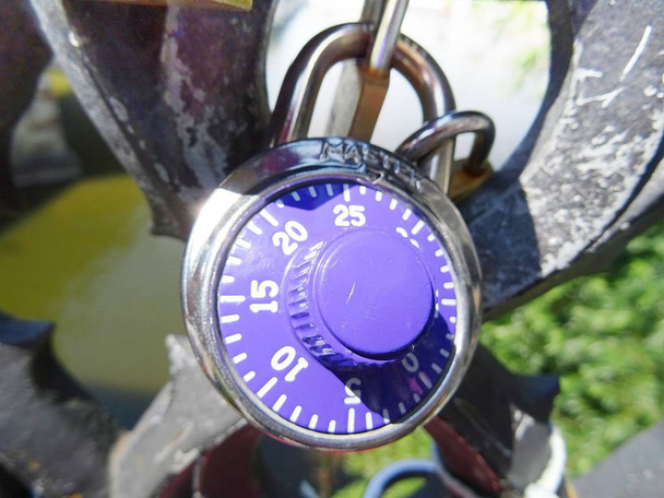 Cadeado de combinação violeta em uma ponte. Conceptual fundo do amor
 - Foto, Imagem
