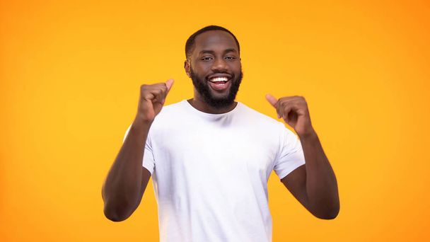 Happy african american man dancing on yellow background, celebrating success - Photo, Image
