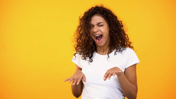 Joyful curly-haired woman dancing celebrating success, good mood, moving music - Foto, afbeelding