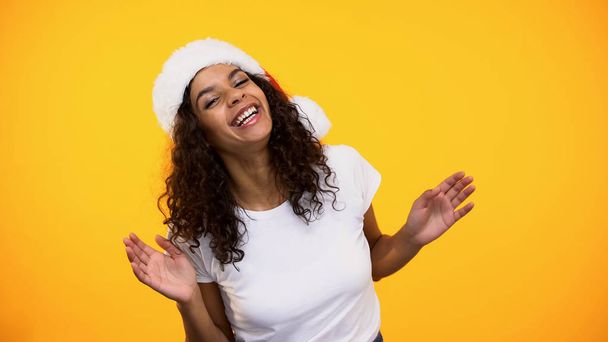 Happy young woman in santa claus hat having fun smiling on camera, greeting - Photo, Image
