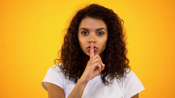 Curly haired woman showing silence gesture, keeping secrets, private information - Photo, Image