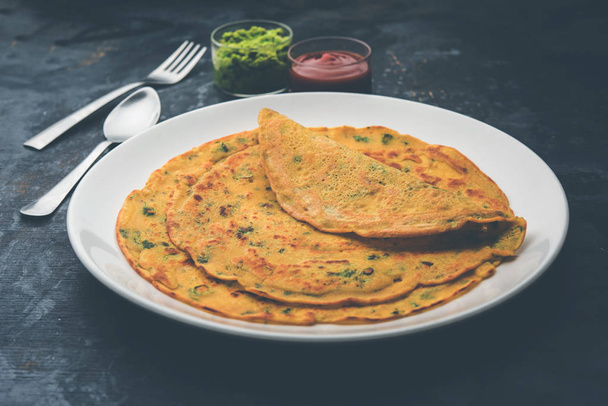 Chilla ή Besan Cheela είναι μια απλή τηγανίτα γίνεται με αλεύρι ρεβίθια και μερικά βασικά συστατικά που σερβίρονται με πράσινη chutney και σάλτσα ντομάτας, επίσης γνωστή ως veg-ομελέτα - Φωτογραφία, εικόνα