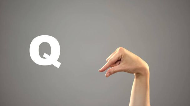 Letter Q in sign language, hand on background, communication for deaf, lesson - Foto, afbeelding