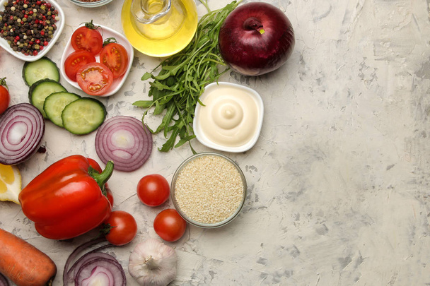 Ingrediënten voor het koken van salade. Verschillende groenten en specerijen wortelen, tomaten, uien, komkommers, paprika en rucola op een lichte achtergrond. Top View. - Foto, afbeelding