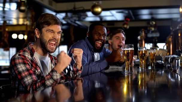 Enthusiastic multiethnic men celebrating victory of favorite sports team, win - Fotó, kép