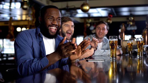 Multiracial male friends celebrating favorite team victory, enjoying time in bar - Zdjęcie, obraz