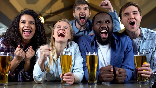 Young multi-racial friends rooting for favorite team, watching championship pub - Photo, Image