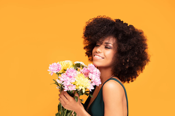 Beauty afro woman with fresh flowers. - Фото, изображение
