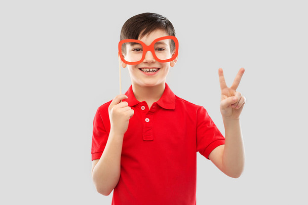 smiling boy with big paper glasses showing peace - Foto, Bild