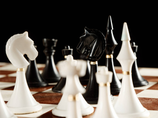 chess pieces on the board on a black background - Foto, immagini