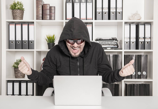 Hombre hacker utilizando el ordenador portátil y romper la contraseña abierta en la oficina
 - Foto, imagen