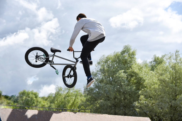 Adolescente monta una bicicleta de acrobacias extrema
 - Foto, Imagen