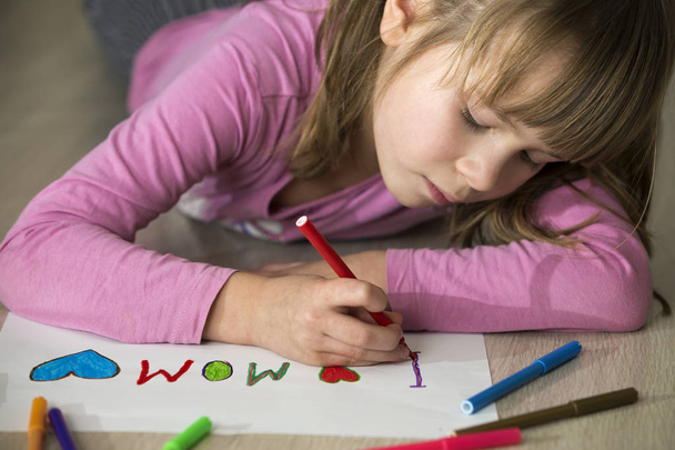 Schattig kind meisje tekening met kleurrijke kleurpotloden ik hou van moeder op wit papier. Kunstzinnige vorming, creativiteit concept. - Foto, afbeelding