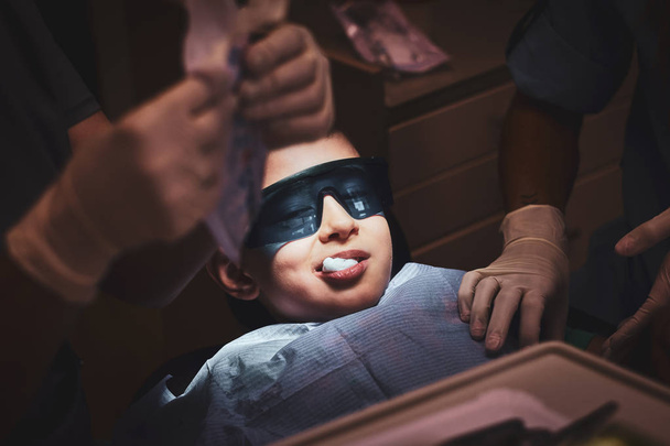 Dental operation is over, little boy try to smile - Foto, Imagen
