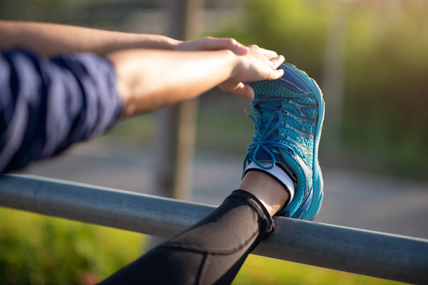 Runner mulher alongamento muscular perna preparando no parque verde em su
 - Foto, Imagem