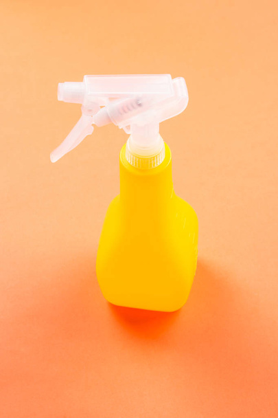 Flacone spray giallo per la pulizia su arancione
 - Foto, immagini