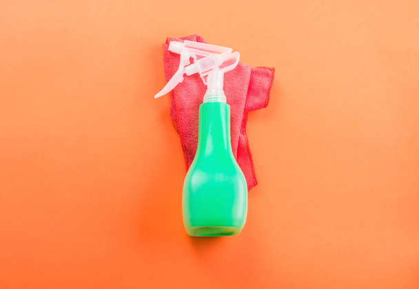 Зелена пляшка спрею на рожевій тканині з мікрофібри
 - Фото, зображення